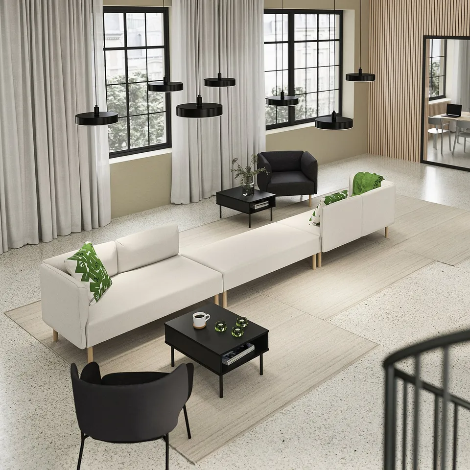 Modern living space with a LILLEHEM modular sofa in white, black coffee tables, and black pendant lights. Large windows with curtains.