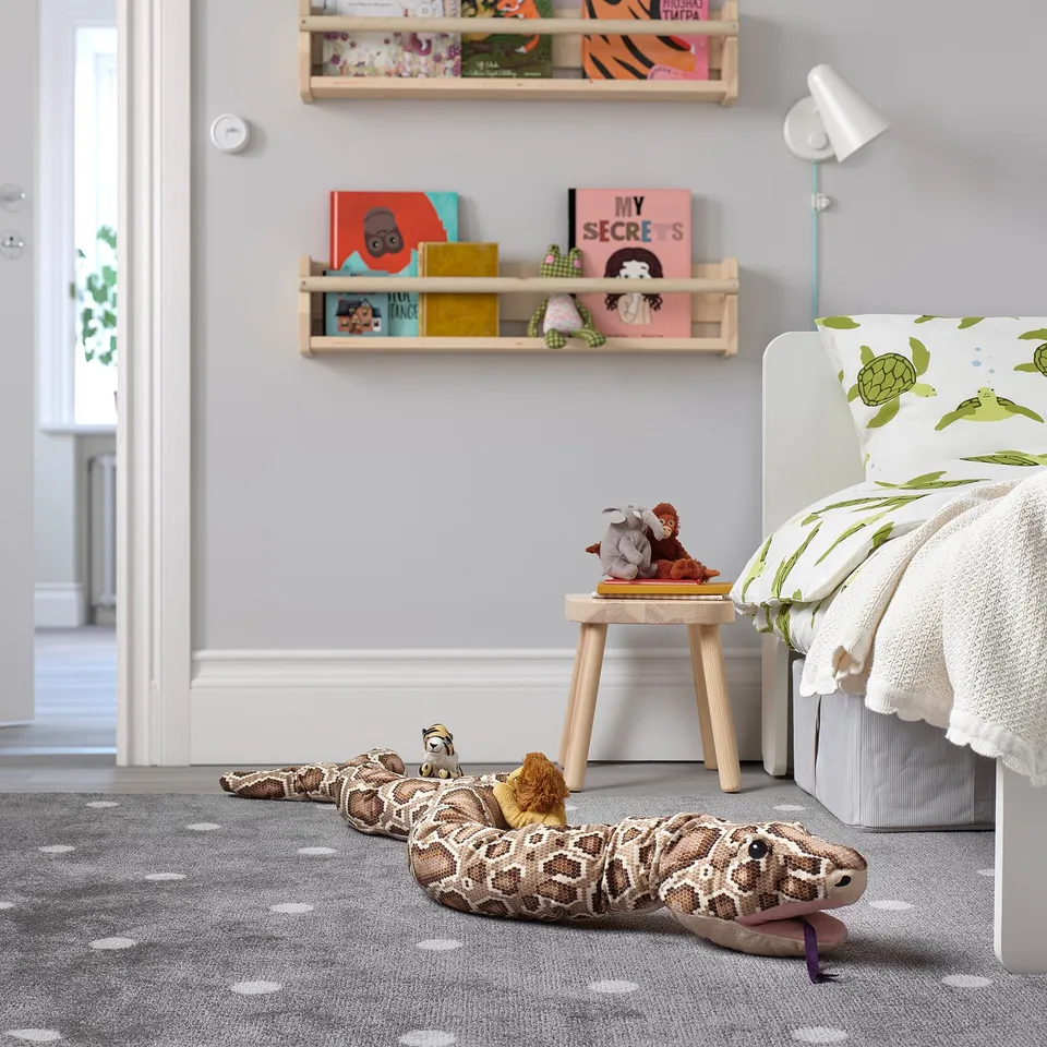 Kids room with DJUNGELSKOG snake toy, books, & decor.