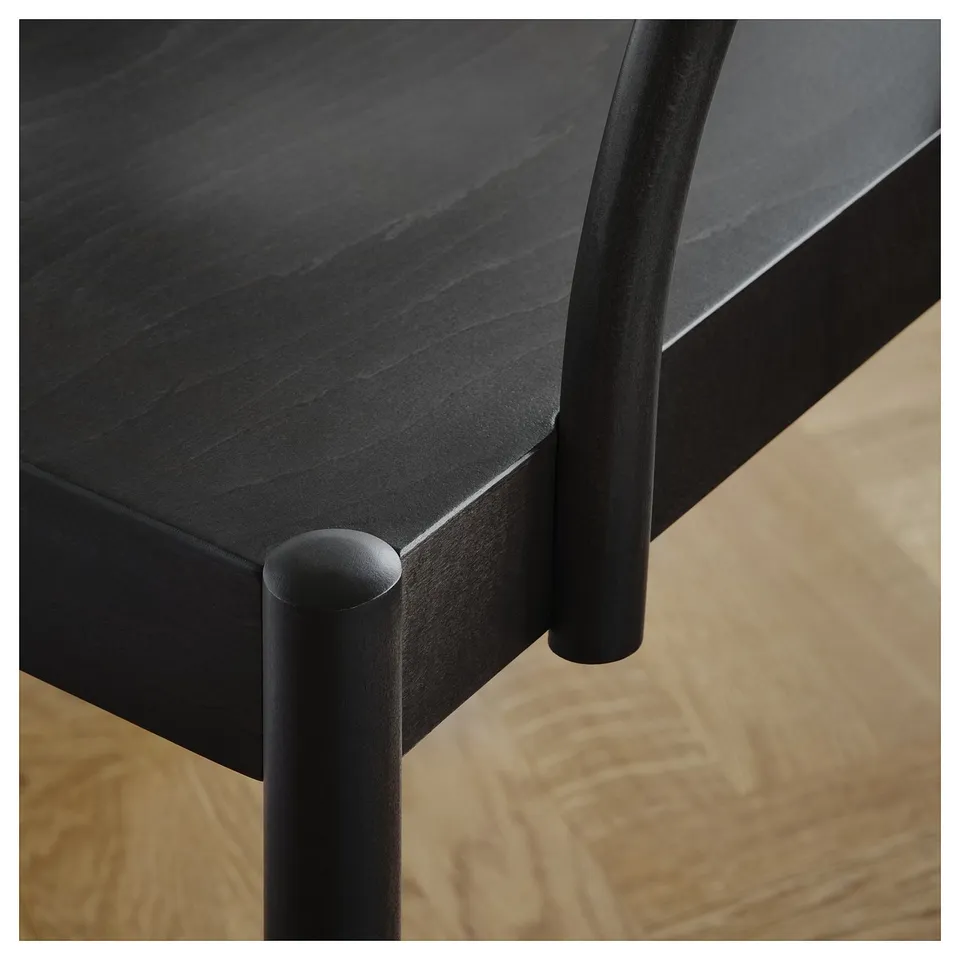 Modern black dining table with sleek, curved metal legs, crafted with high-quality veneer and acrylic finish for durability and elegance.