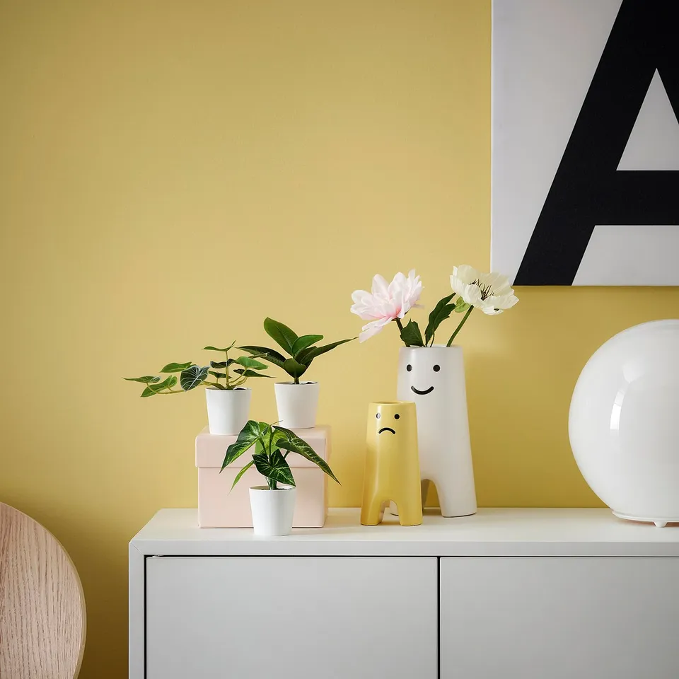 FEJKA trio: mini green plants in white pots, brighten yellow wall. Cute, small, plastic.