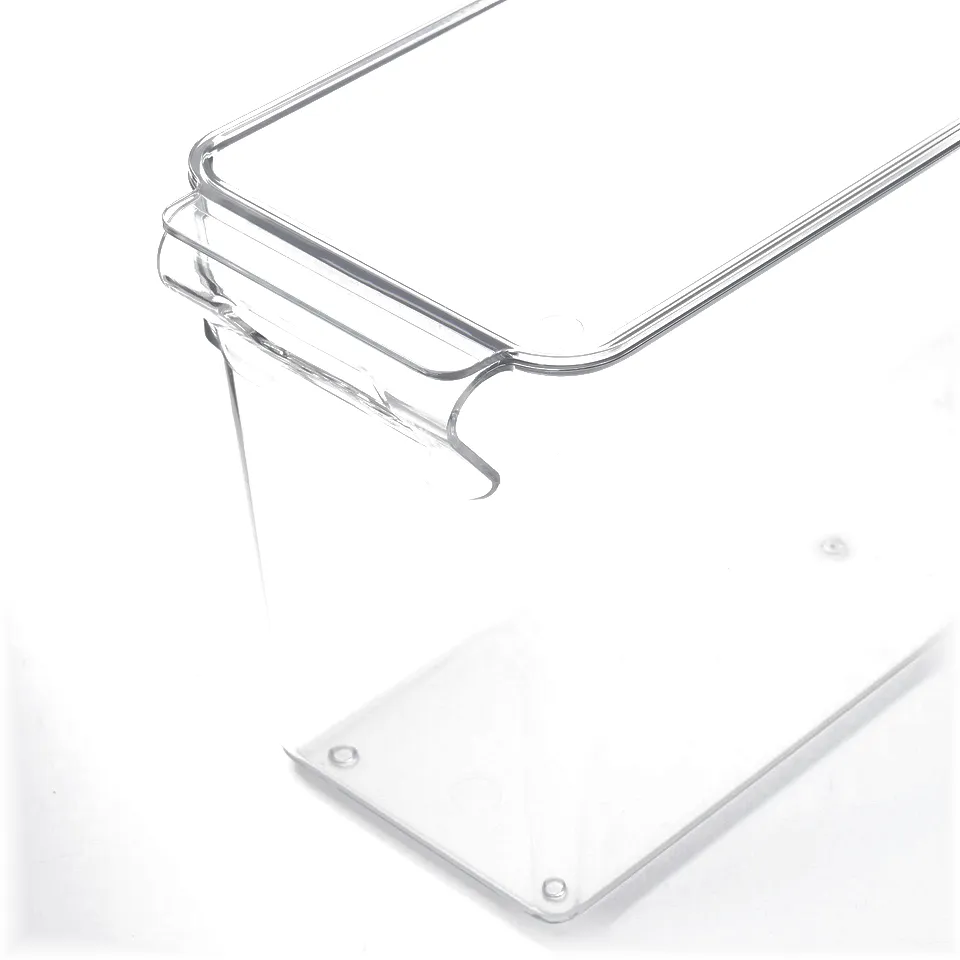 Clear plastic storage box with a sturdy handle, designed for fridge organisation, visible through its transparent walls.