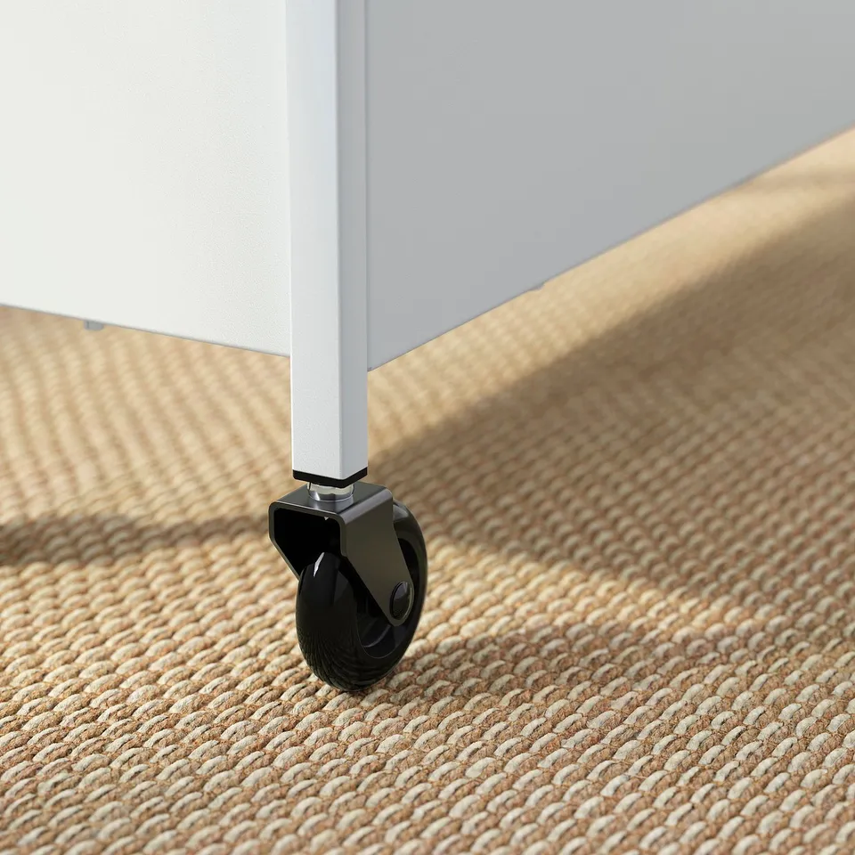 Close-up of a sturdy, modern trolley wheel on a woven, textured carpet. Metal frame indicates high quality.