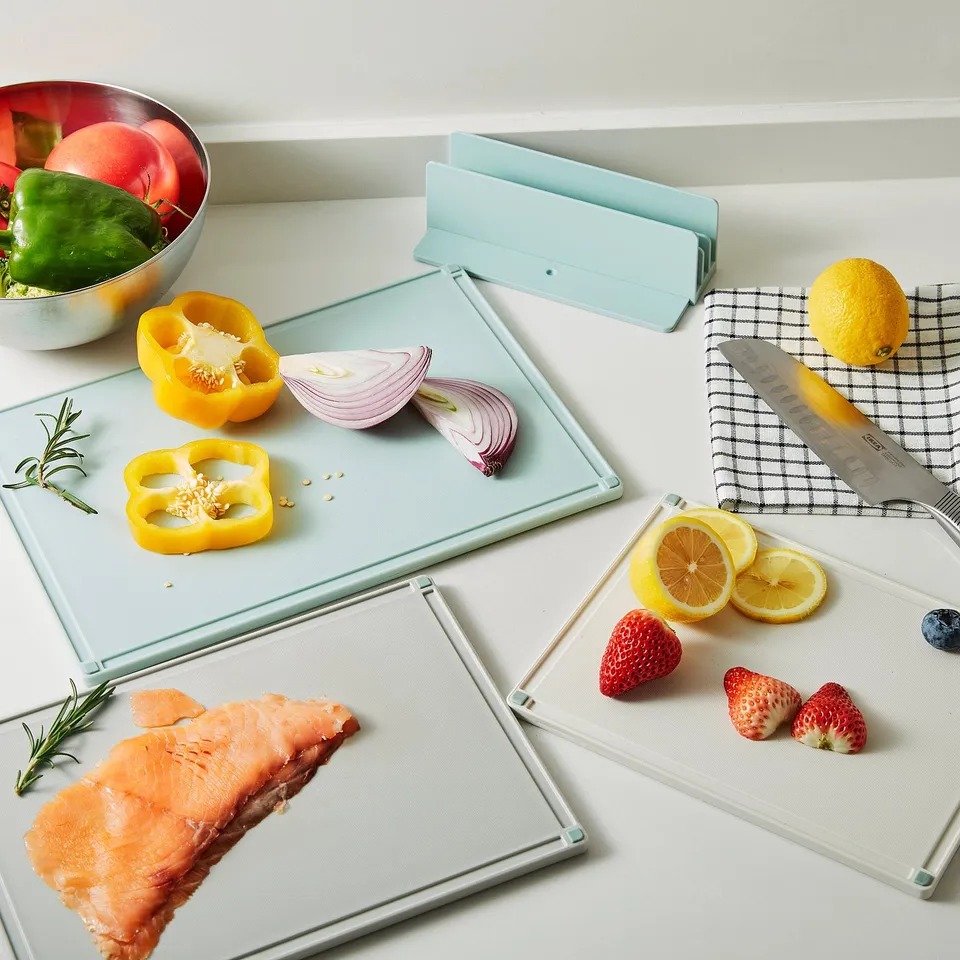 Three color-coded cutting boards with fresh produce and fish, grooves to catch juices, non-slip ends.