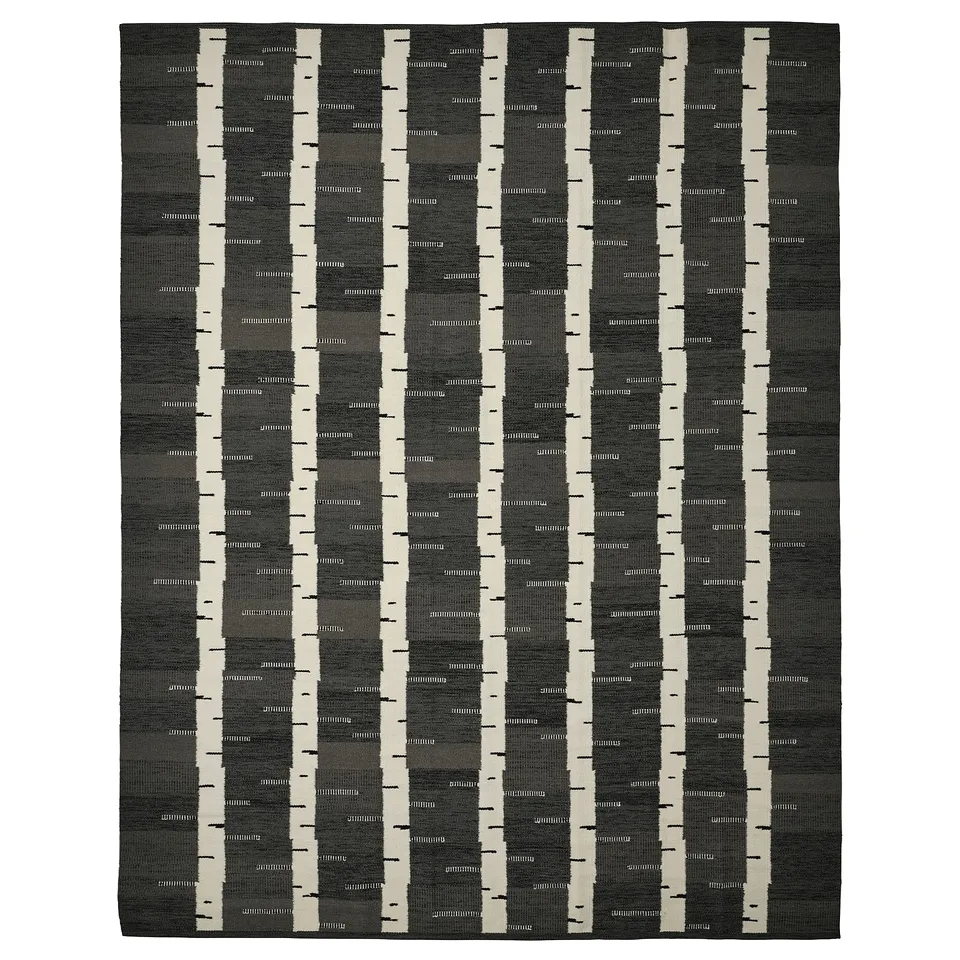 Depicts a rectangular grey and cream handwoven wool rug with a birch tree pattern, part of the stockholm collection.