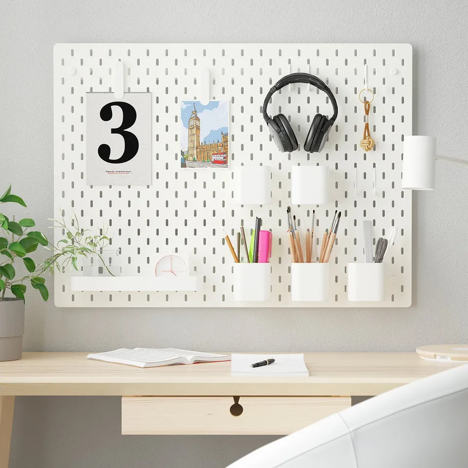 White SKÅDIS pegboard desk organisation with stationery and headphones