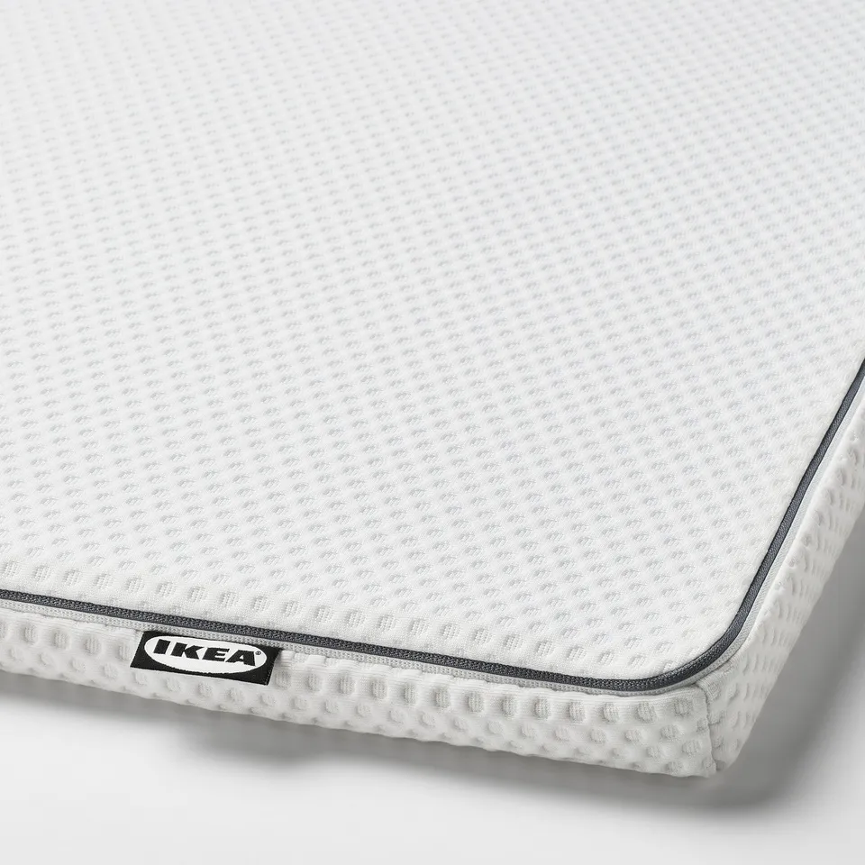 Close-up of ikea mattress pad with textured, breathable top, zipper detail, showing quality craftsmanship.