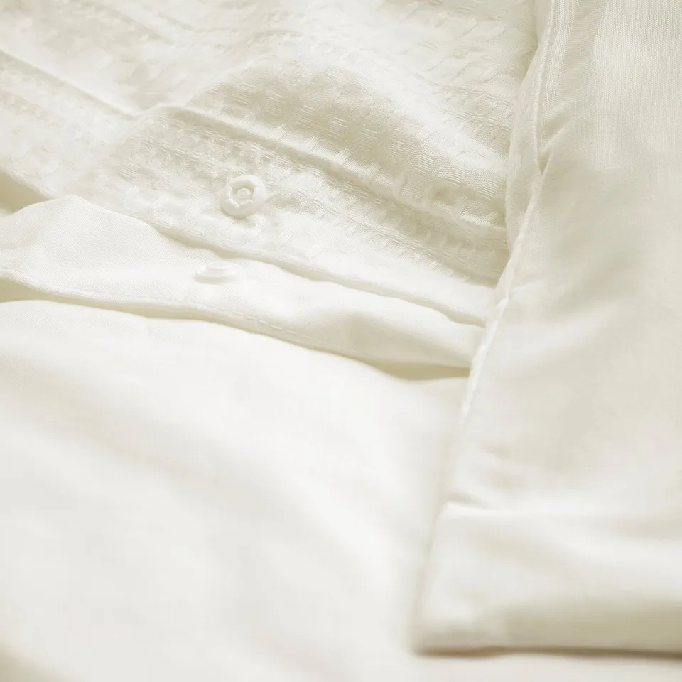 White waffle-weave duvet set with button closure, showcasing soft, breathable cotton texture.