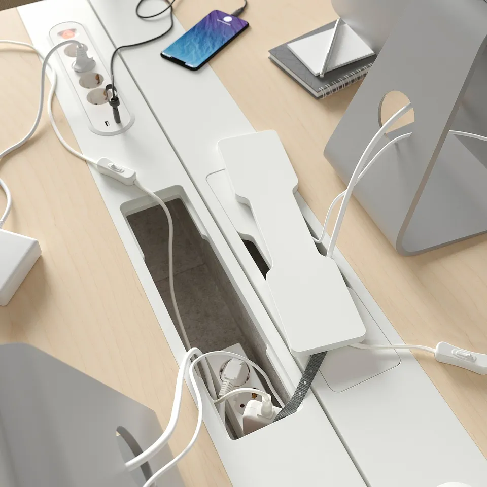 Desk with built-in power outlets and cable tray for managing cords neatly.
