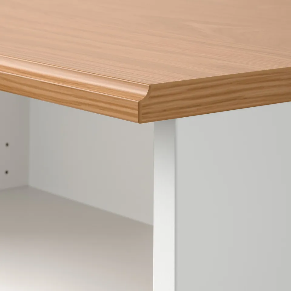 Close-up of SKRUVBY wooden table edge, smooth oak finish over white base, showcasing quality craftsmanship.