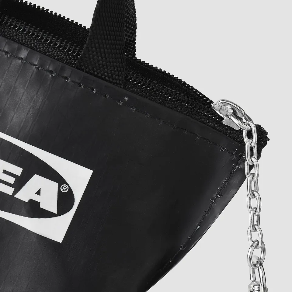 Black keychain bag with zip, branded logo, and metal chain attachment.