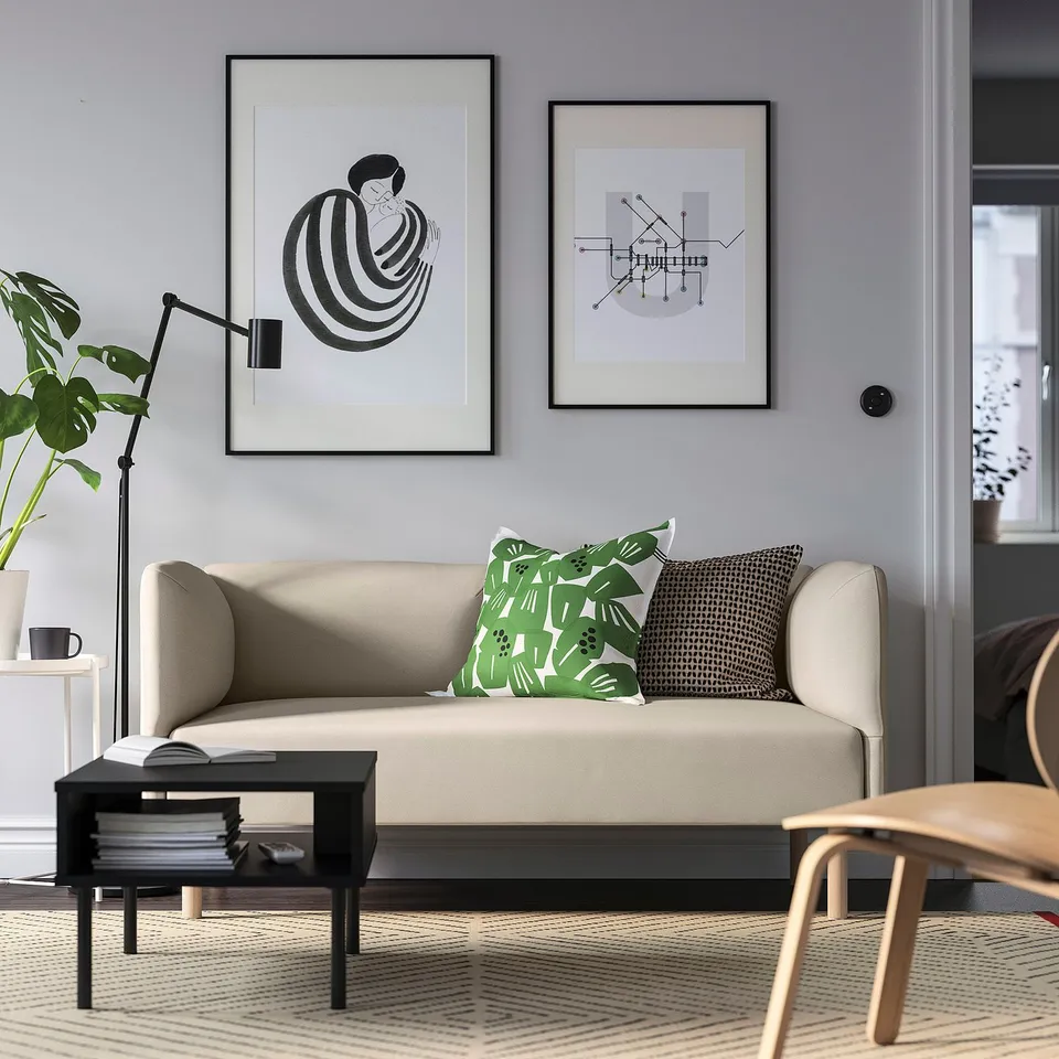 Modern LILLEHEM sofa in beige living room with abstract art, decorative pillows, side table, lamp, and plant.