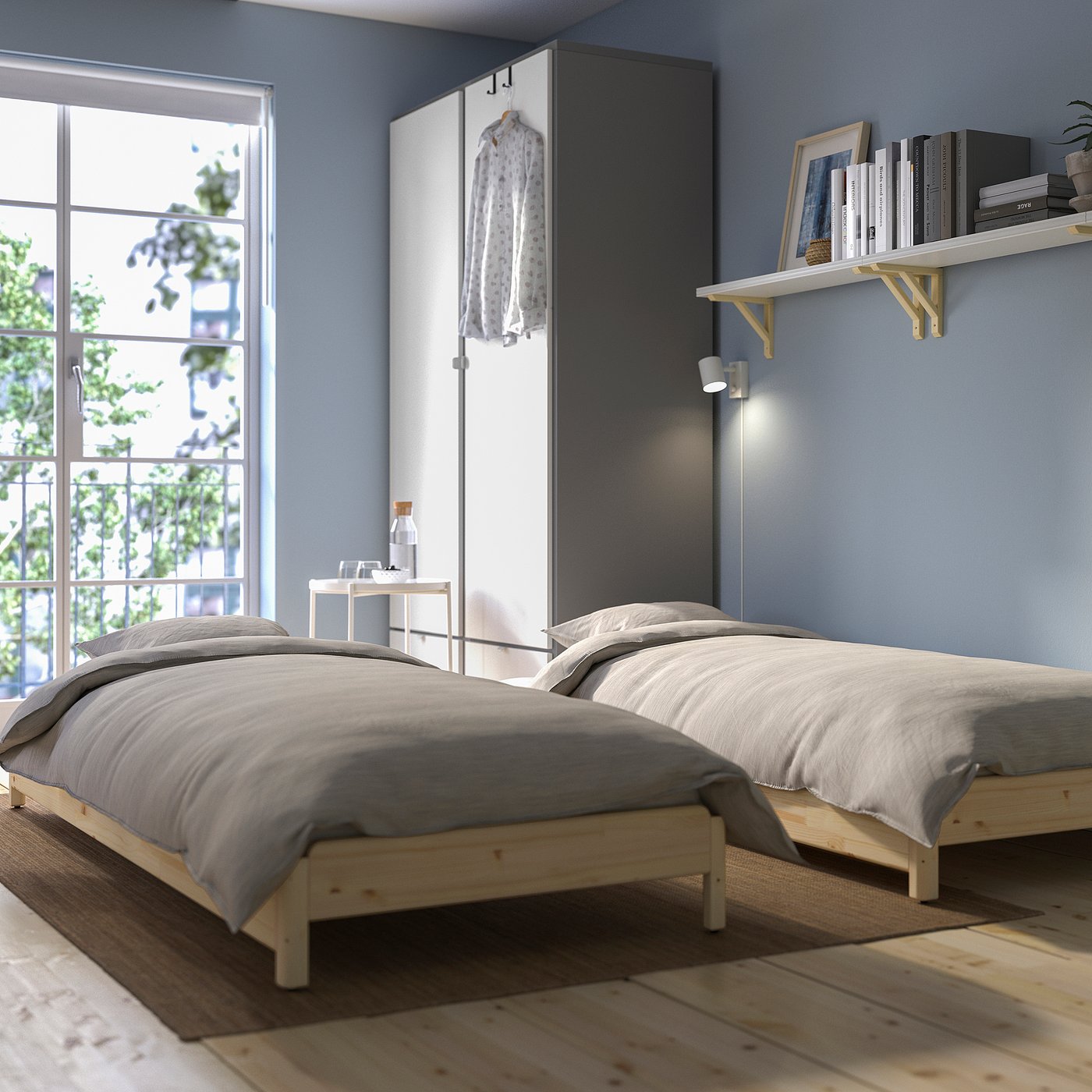 Minimalist bedroom with 2 convertible UTÅKER beds, one stacked as sofa, grey bedding.