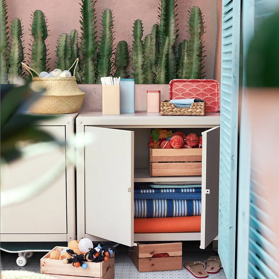 KOLBJÖRN grey storage cabinet with cacti, baskets, and sandals; perfect for balcony or hallway.