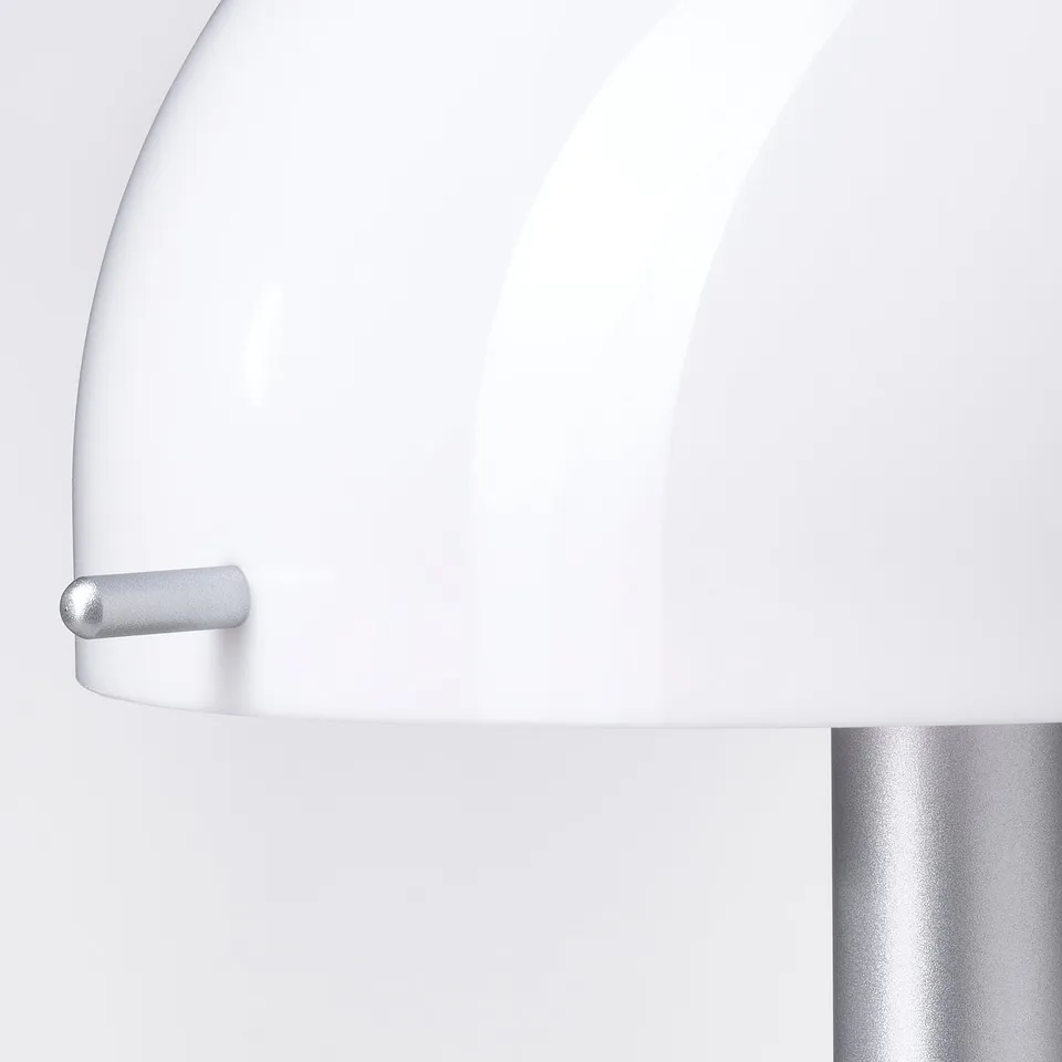Minimalist lamp with sleek white and silver design. Soft, rounded edges, and smooth finish.