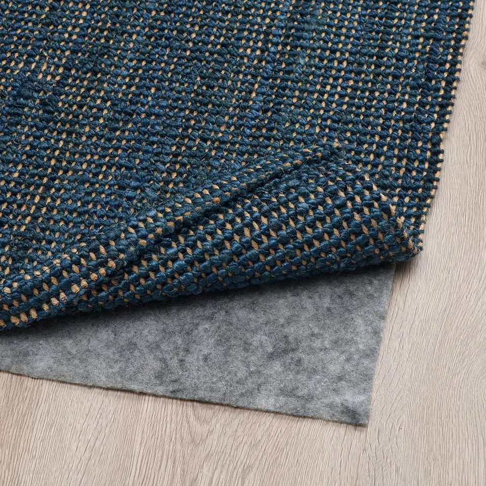 Dark blue jute rug and grey rug pad; provides comfort and stability