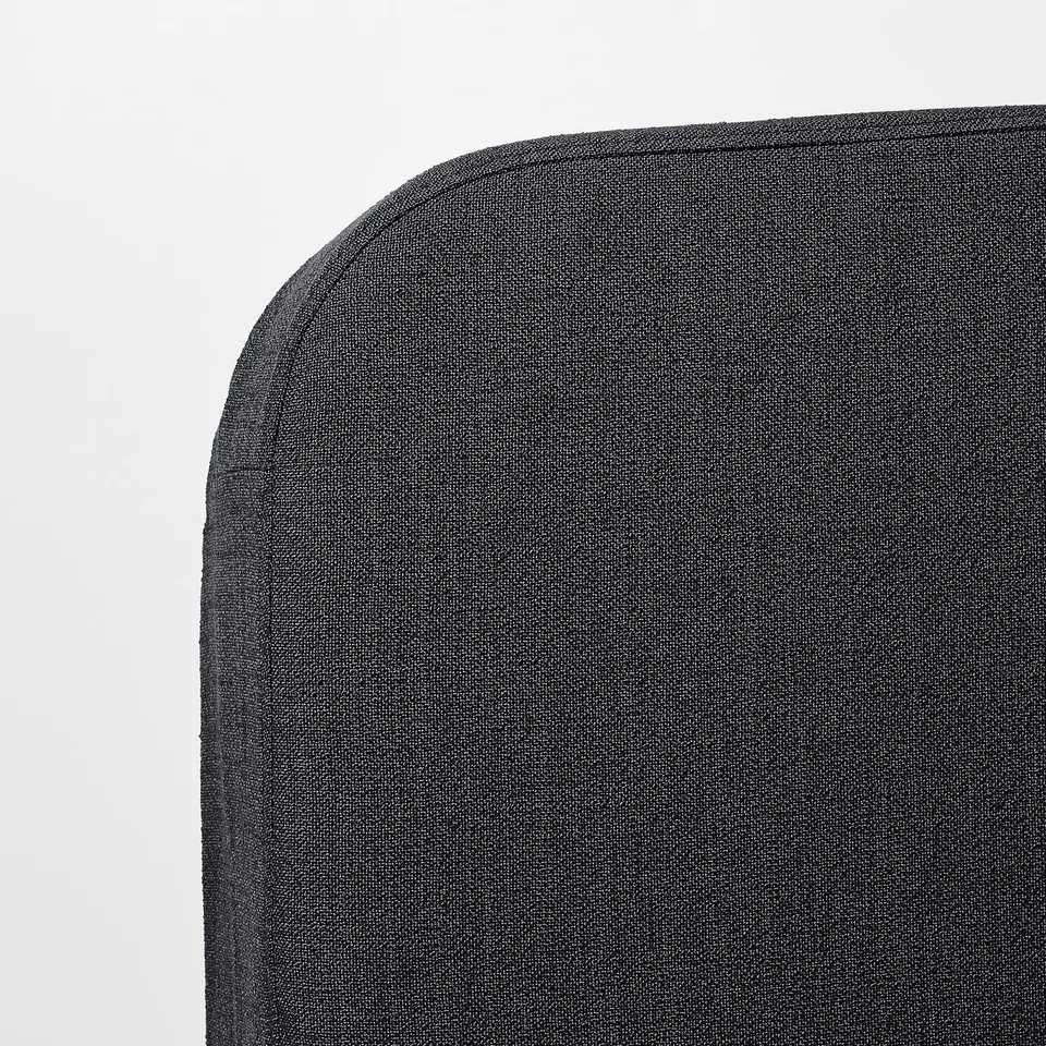 Dark grey upholstered sofa bed corner, showing quality fabric and neat stitching.