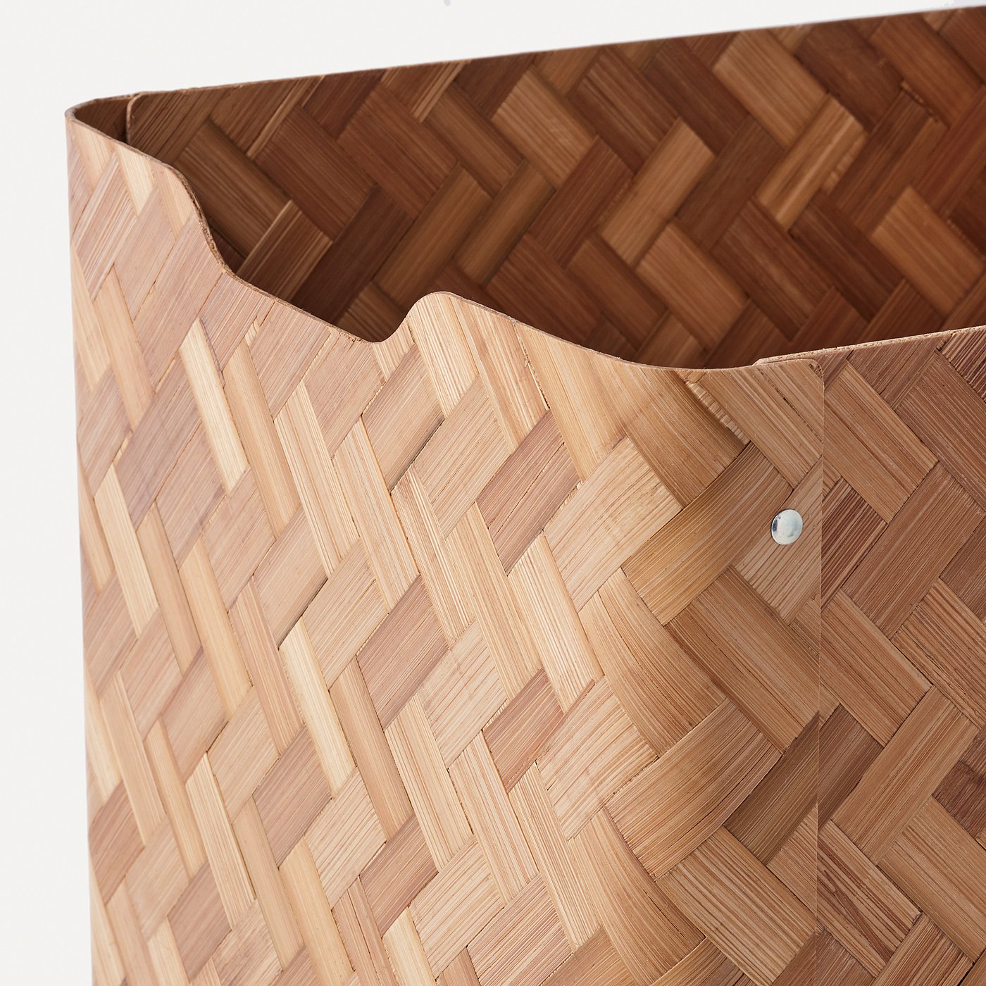 Wicker basket woven from light brown bamboo, showcasing intricate pattern and sturdy construction, positioned against a plain white background.