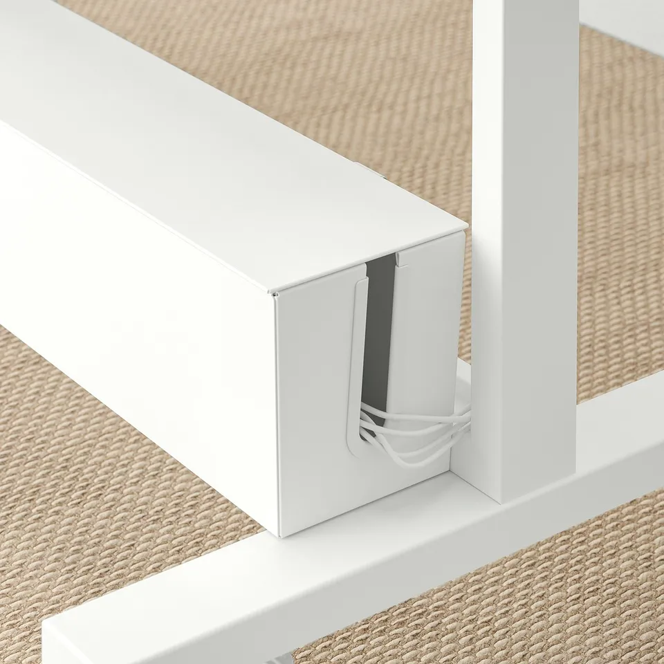 Image shows a modular room divider with built-in cable management and plant containers. A white structure with a slot for wires.