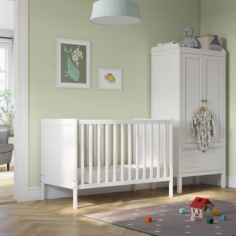 Nursery with SUNDVIK crib, colourful art, blue toy, rug, and toys.