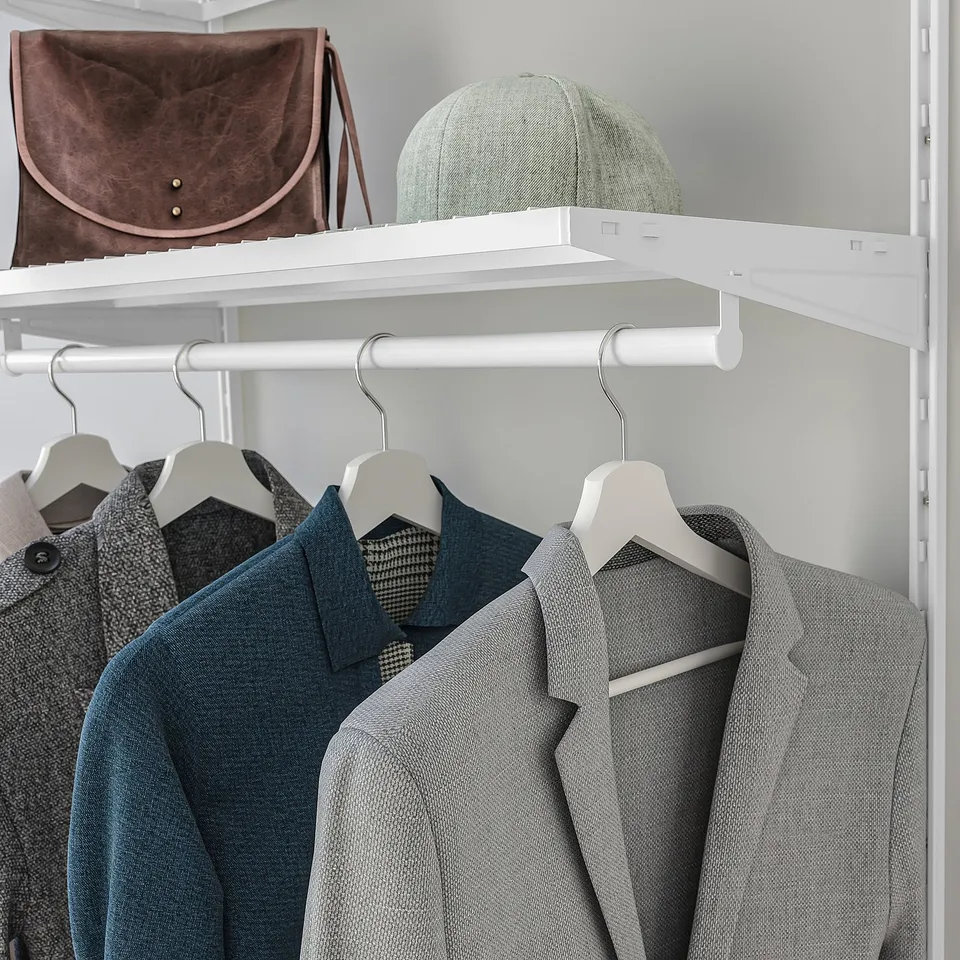 Closet with hanging suits, space for hat and bag on shelf.