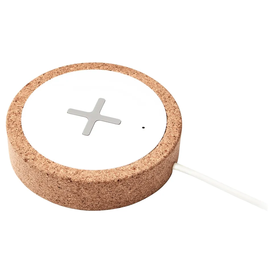 Nordmarke wireless charger: round, cork-brown, metallic centre, white cable.