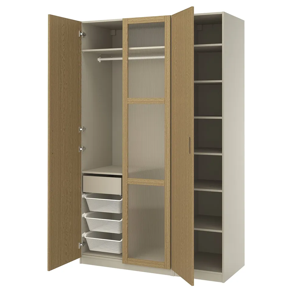 An open beige-brown ikea PAX wardrobe with shelves, drawers, and hanging space, featuring wooden doors with glass panels and mesh baskets for storage.