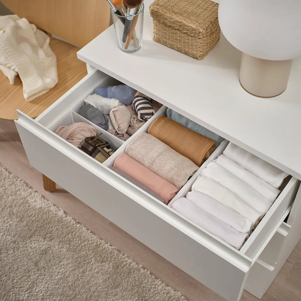 Well-organized drawers with folded clothes, using space efficiently. Drawing shows smooth drawer runners and tidy storage solution.
