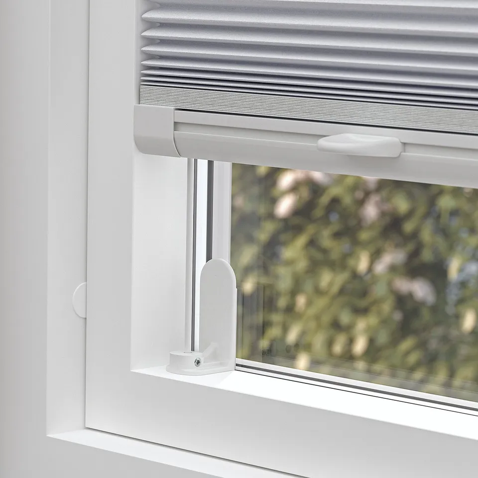 Cordless pleated blind, fits various windows, blocks light.