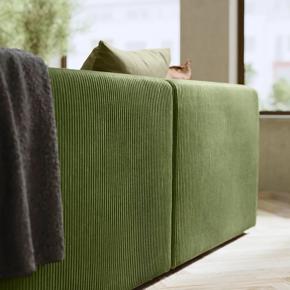 A modern green JÄTTEBO sofa with vertical lines and a cat resting on it.