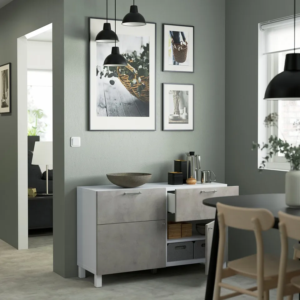 Modern dining setup with grey sideboard, photos, and pendant lamps.
