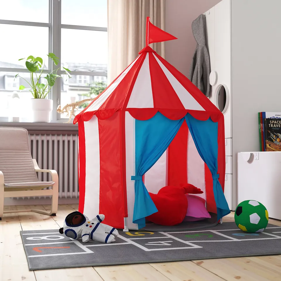 Kids red/blue play tent in living room, with toys around.