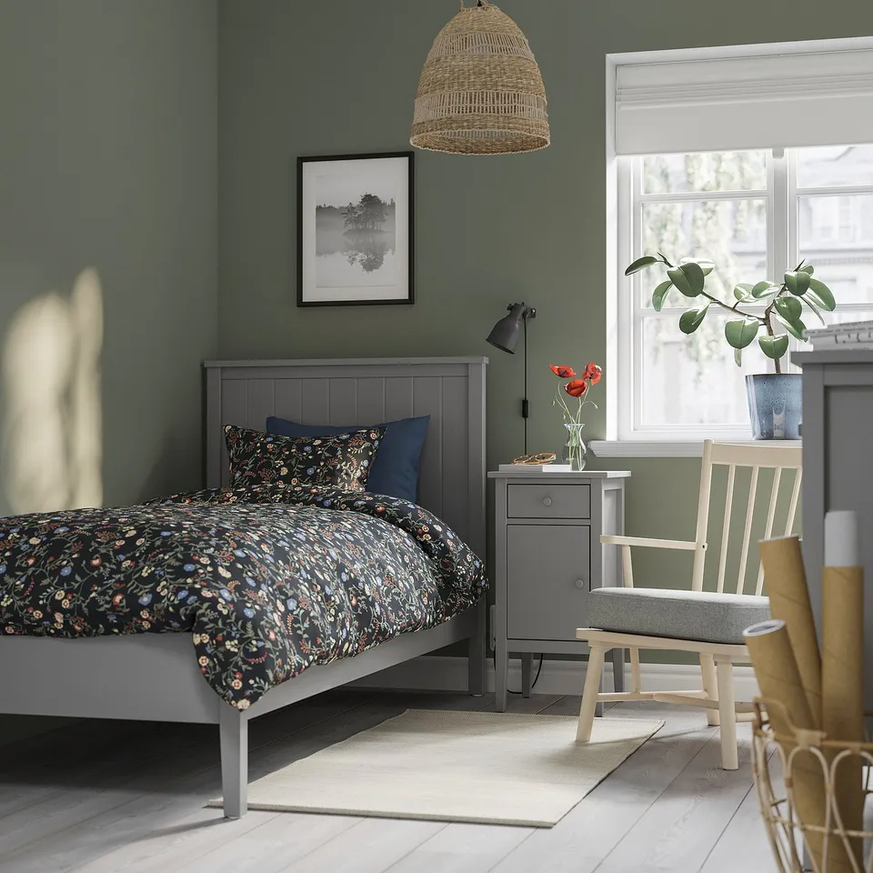 GULLABERG grey bed, floral bedding, grey table, green wall, plant window light.