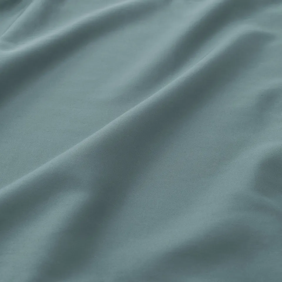 Smooth, luxurious bed sheet in blue-green hue, showcasing fine weave and lustrous finish.