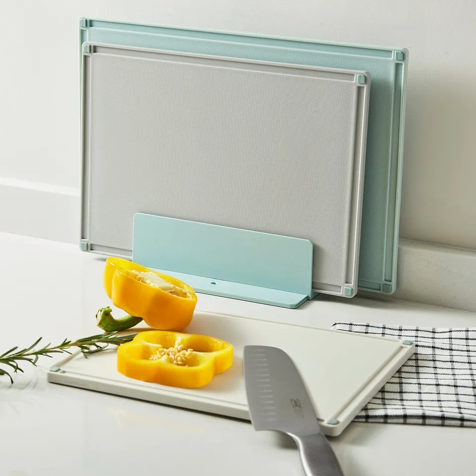 Three interlocking cutting boards with knife, slicing yellow pepper, holder upright.
