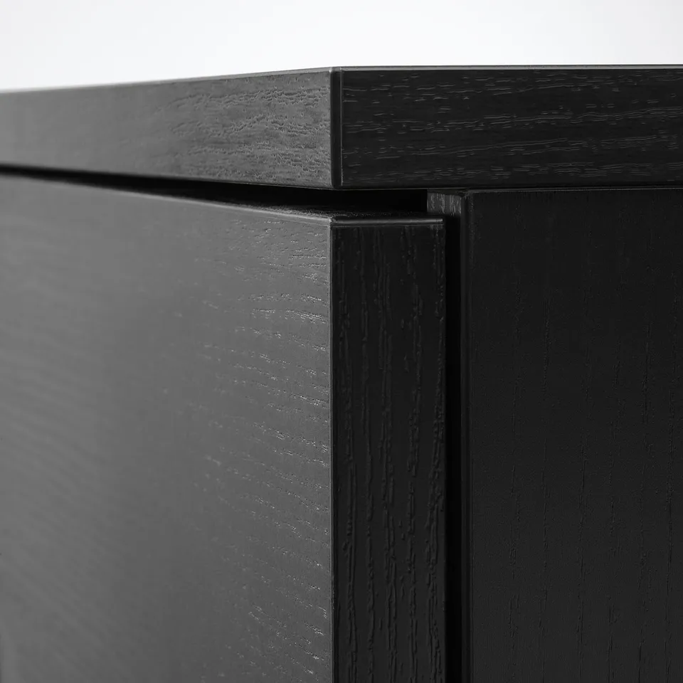 Black wooden furniture close-up; shows sleek, smooth finish and precise joinery.