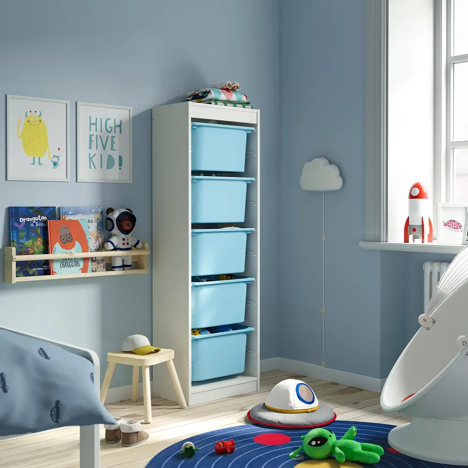 Childrens room with light blue TROFAST storage. Tall, white frame with blue bins, fitting below wall art. Perfect for small spaces, organising toys.