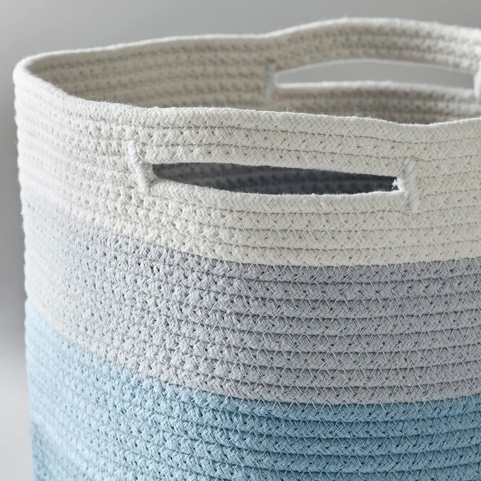 Close-up of a woven cotton basket showing its sturdy, handle details.