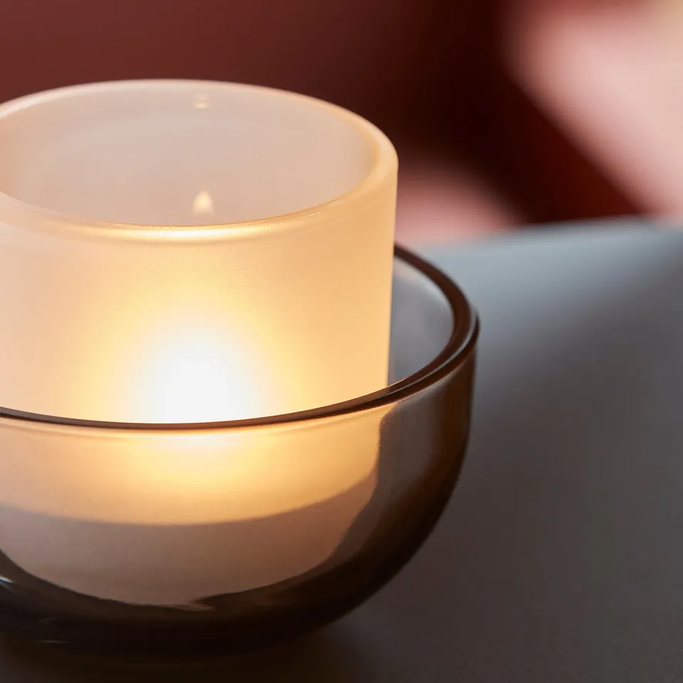 Tealight in glass holder, casting warm glow.