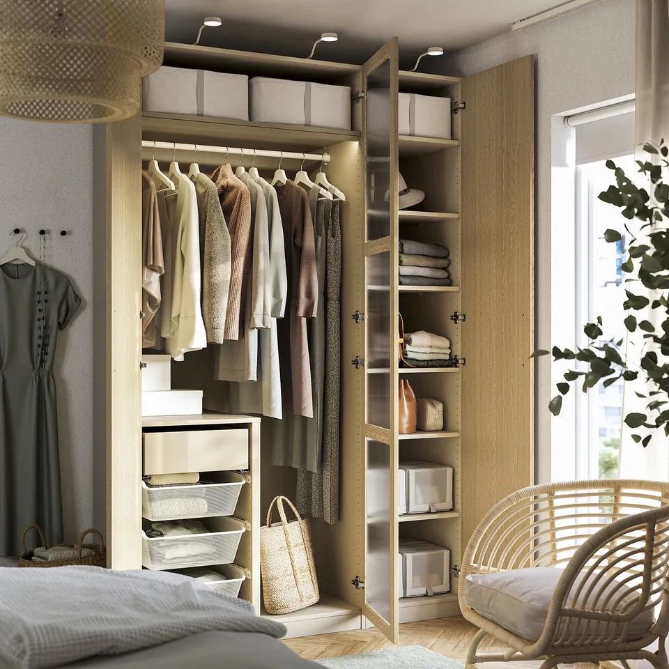 Neat closet with clothes, shelves, and baskets, showing organised storage space. Clothes hangers visible, along with folded items on shelves.