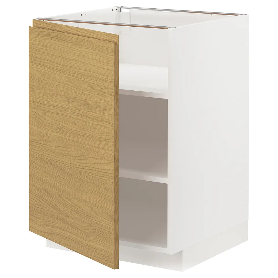 A white METOD kitchen cabinet with a single oak door partially open, revealing an empty interior.