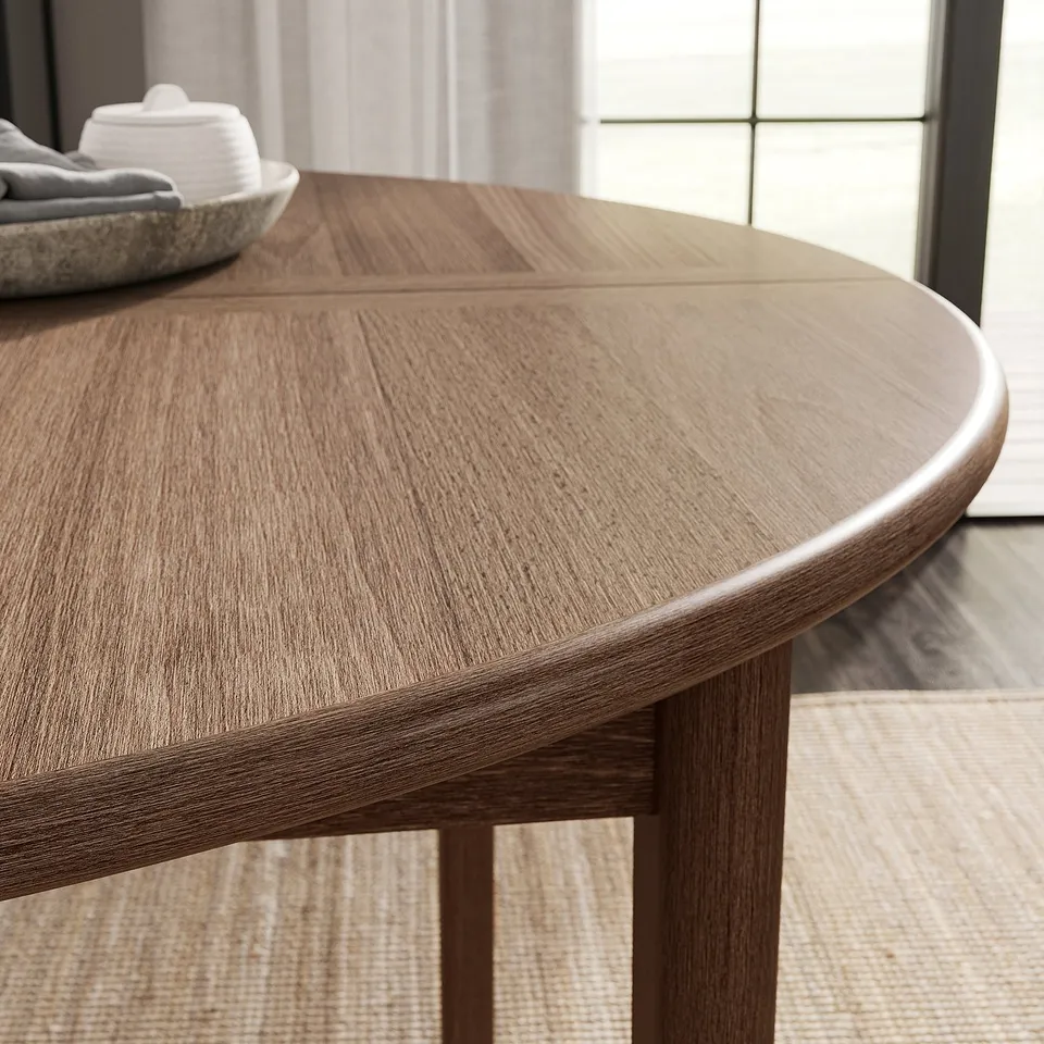 Modern oval dining table with smooth edge, showcasing natural wood grain texture.