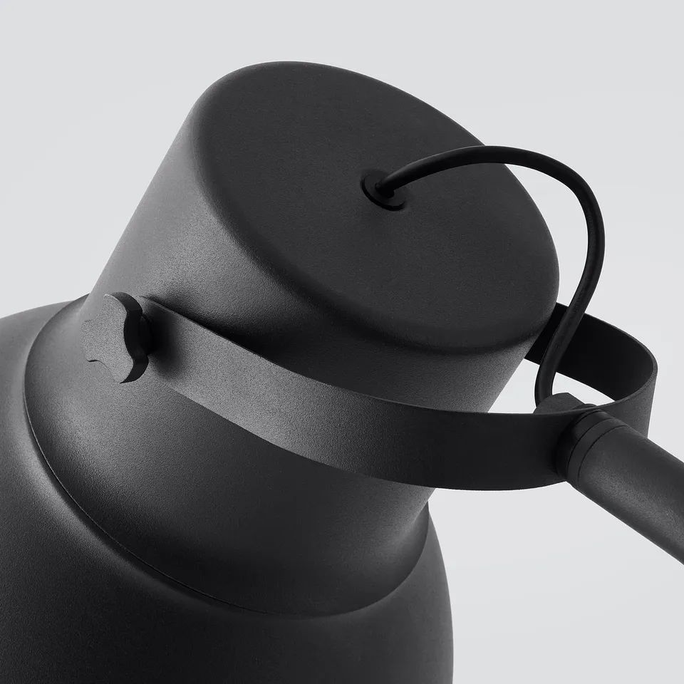Black modern lamp with adjustable neck, white background. Sleek, industrial design with metal finish.