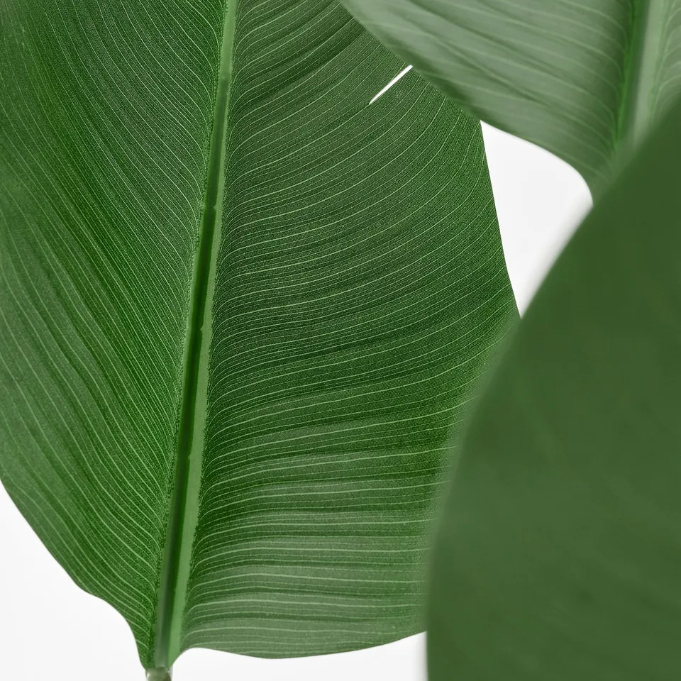 Close-up of vibrant, realistic artificial leaf, showing intricate vein patterns and vivid green colour.