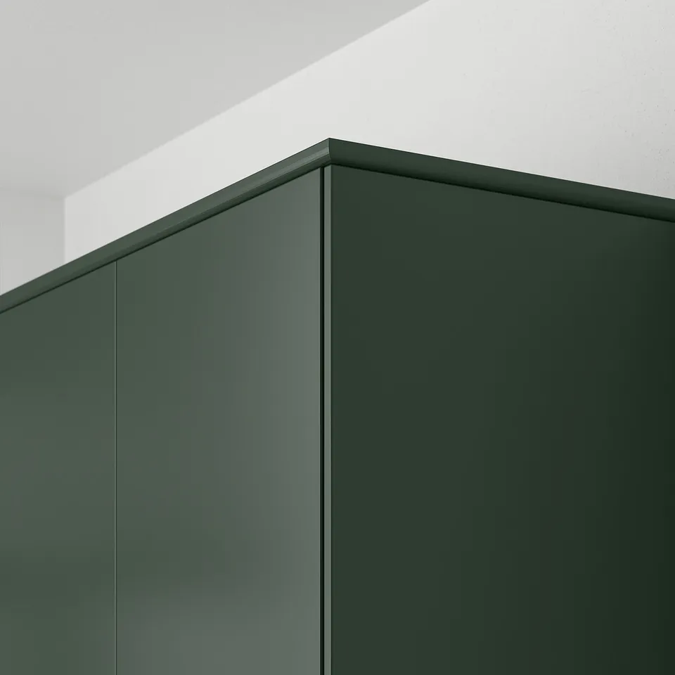 Dark green kitchen cabinet panels with straight lines and smooth surfaces, mounted on a white wall, demonstrating integrated cabinet design.