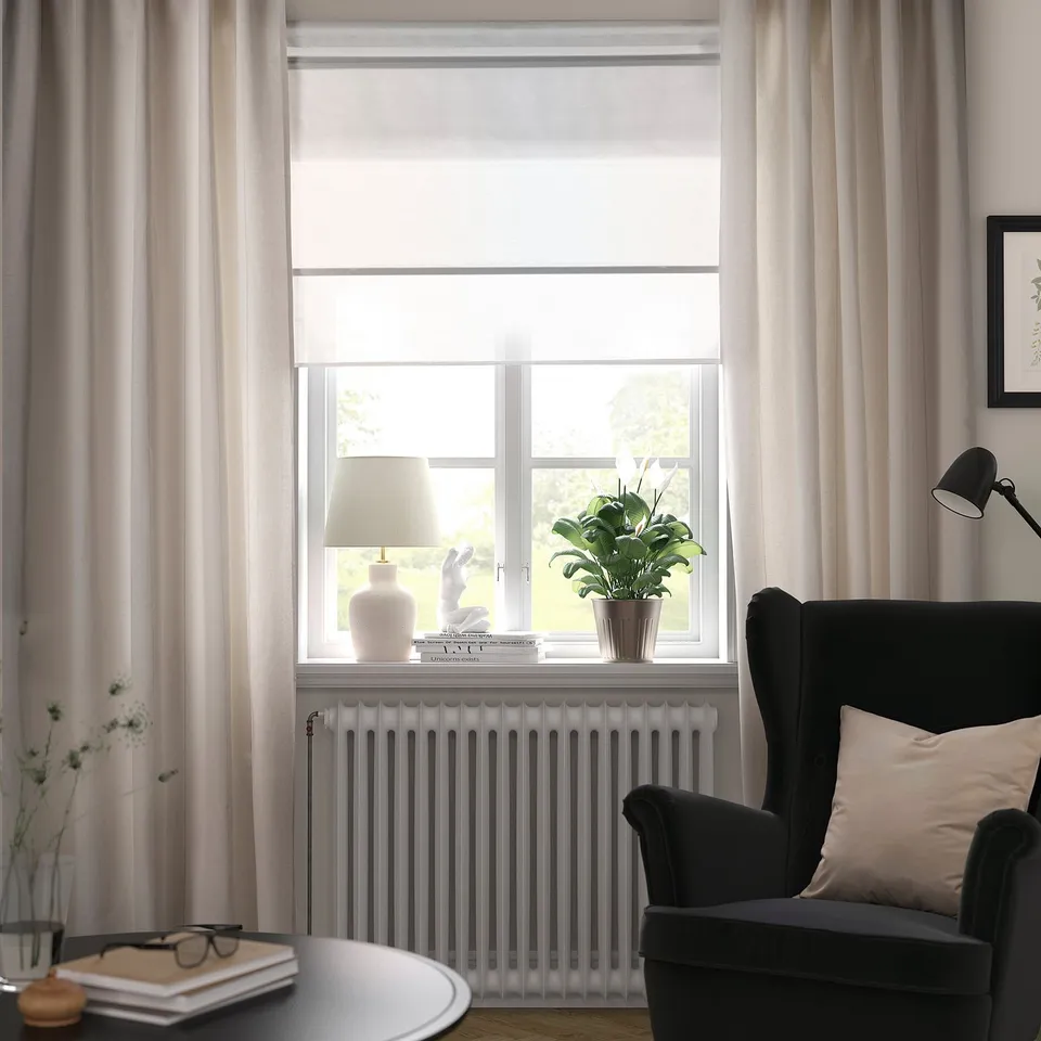 Modern living room with LENDA curtains, black armchair, and green plant.