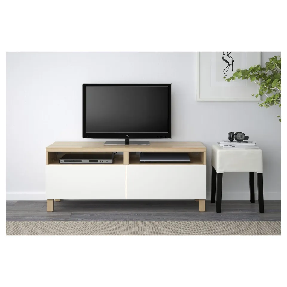 Modern tv stand with open shelving and cable management, silent-close drawers, tv, and headphones.