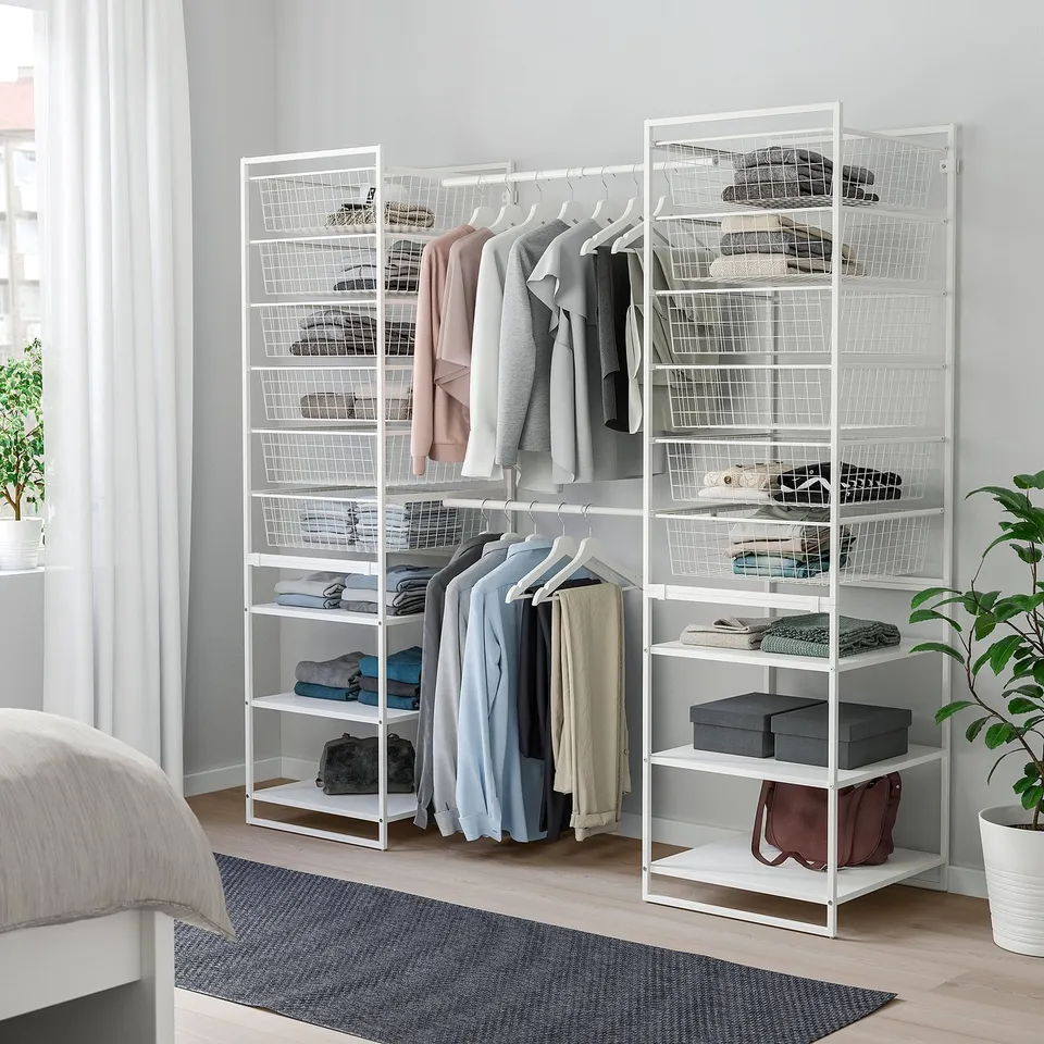 White JONAXEL storage in bedroom with shelves, rails, and wire baskets.
