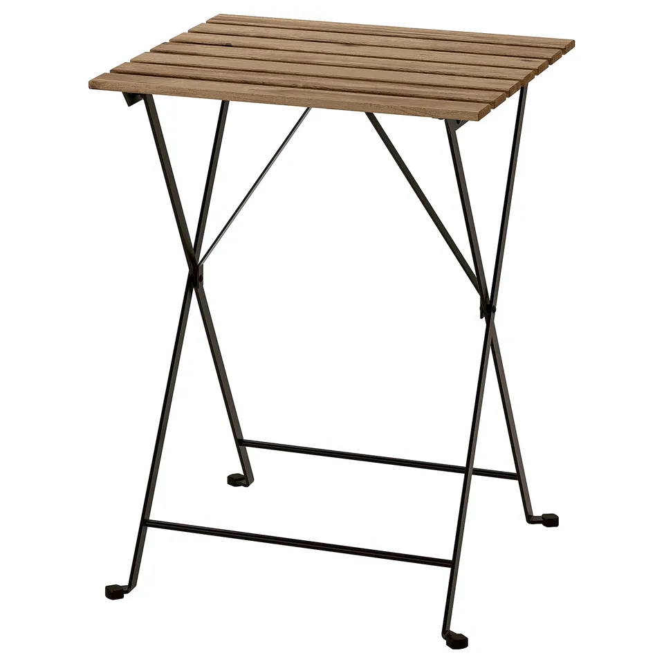 An outdoor TÄRNÖ table, brown, with a wooden top and black metal legs, foldable.