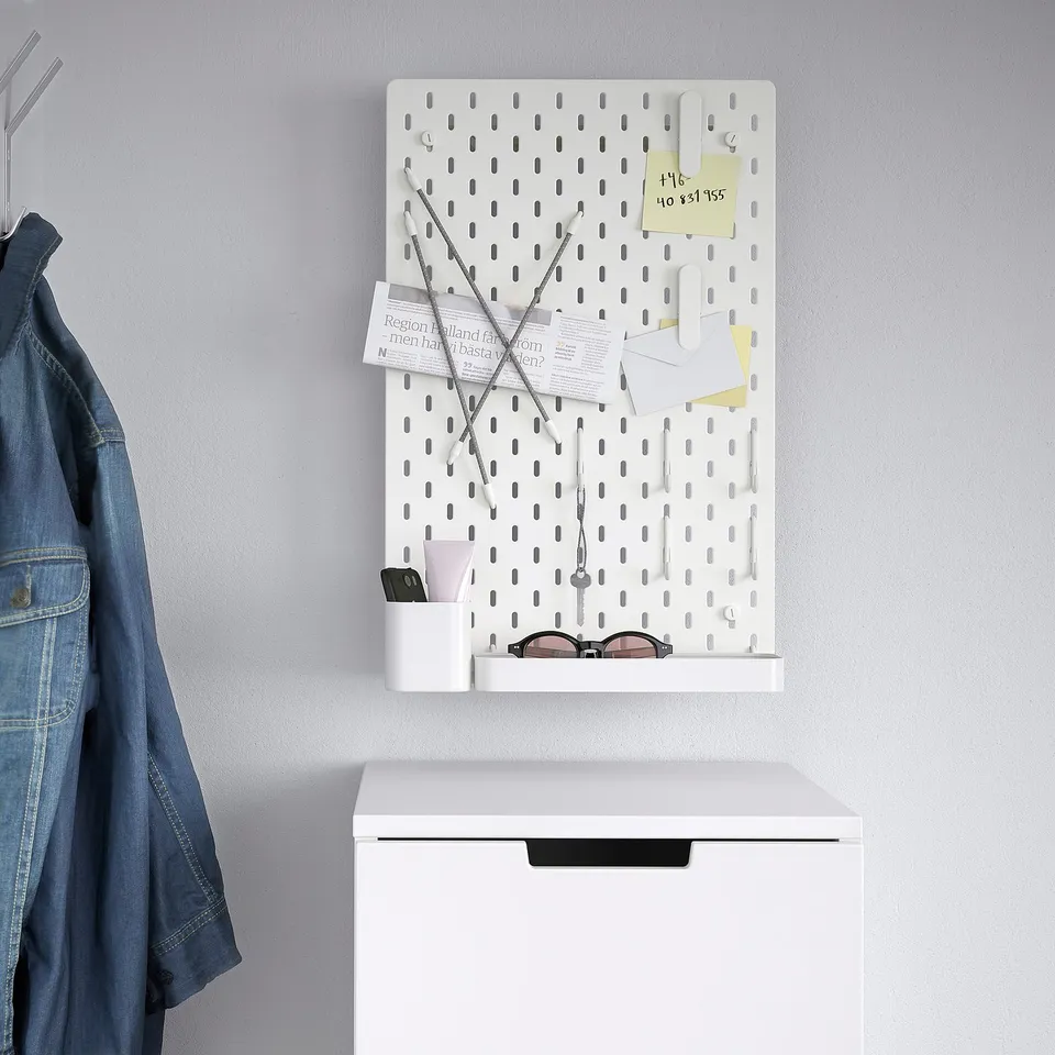 White SKÅDIS pegboard with accessories and hooks.