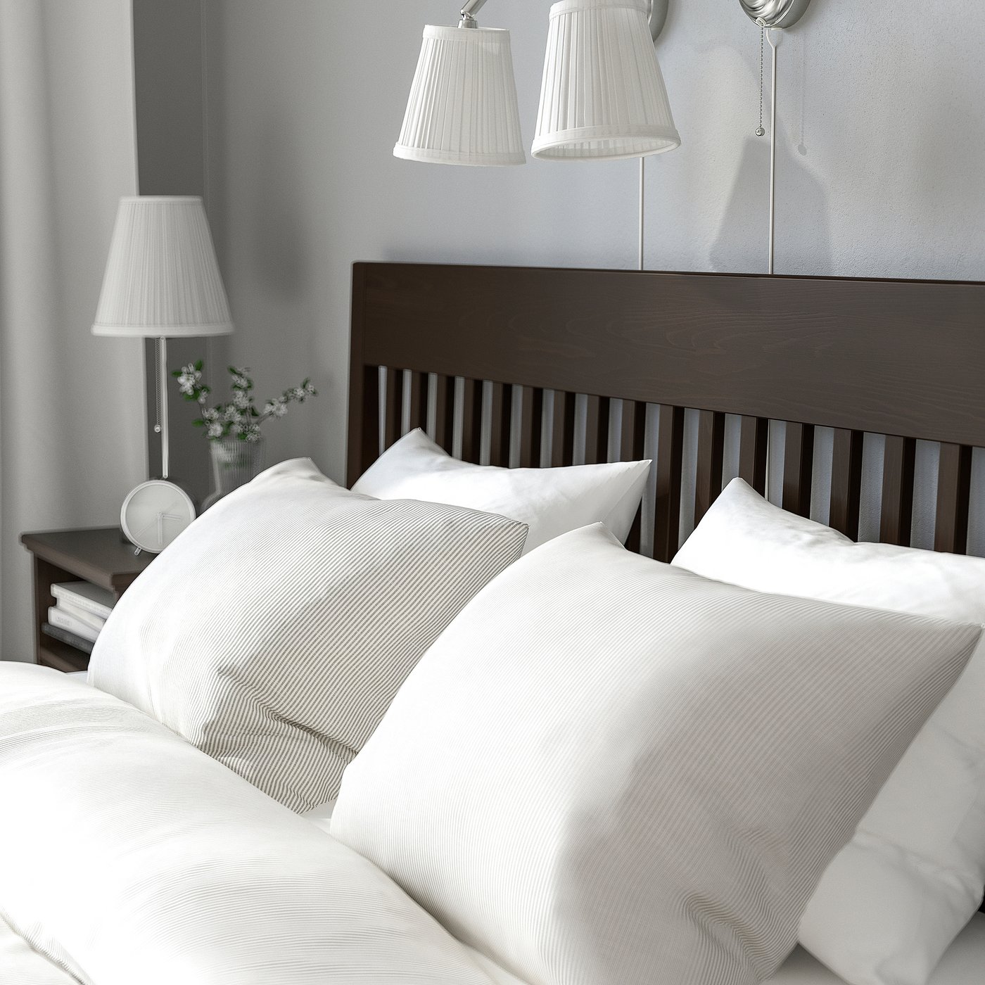 A neatly made bed with white linens, wooden headboard, and bedside lamps; ideal for a cosy bedroom.